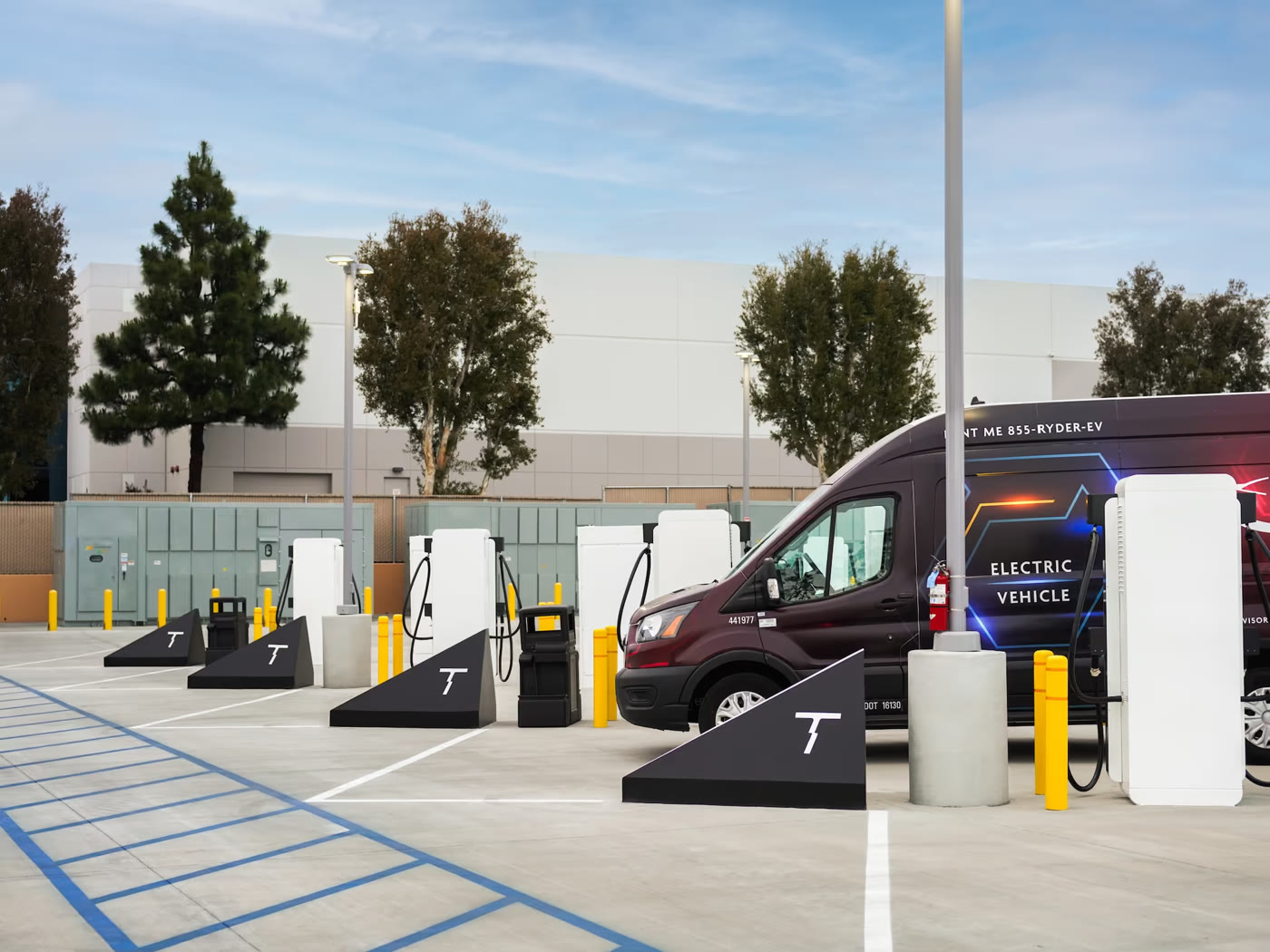 Terawatt-branded charging bays with an electric delivery van plugged in and switchgear behind it